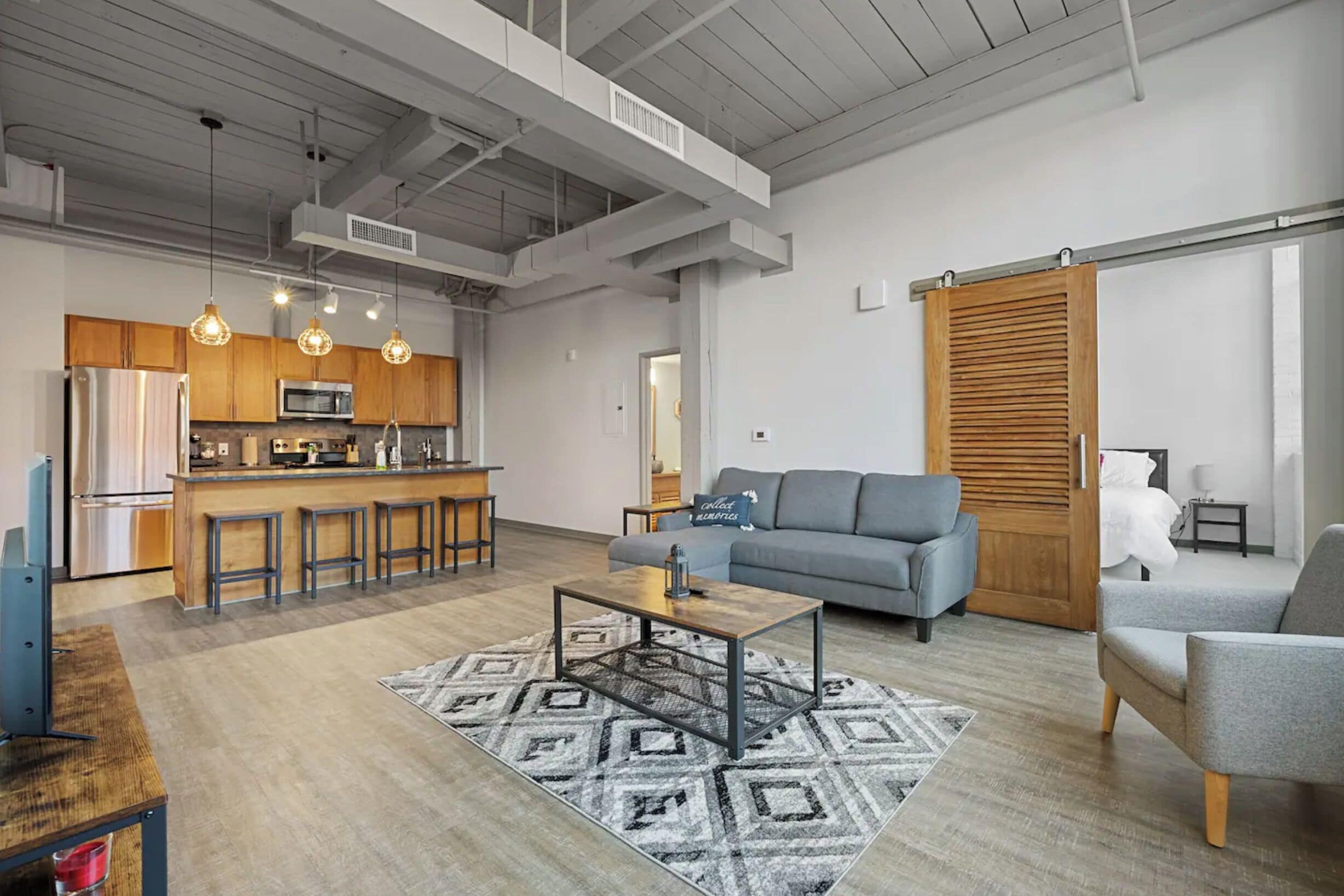A modern apartment with a kitchen, living area, and a large sliding door closet.