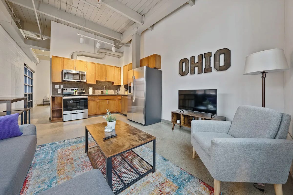 A modern apartment with a kitchen, living room, and a TV.