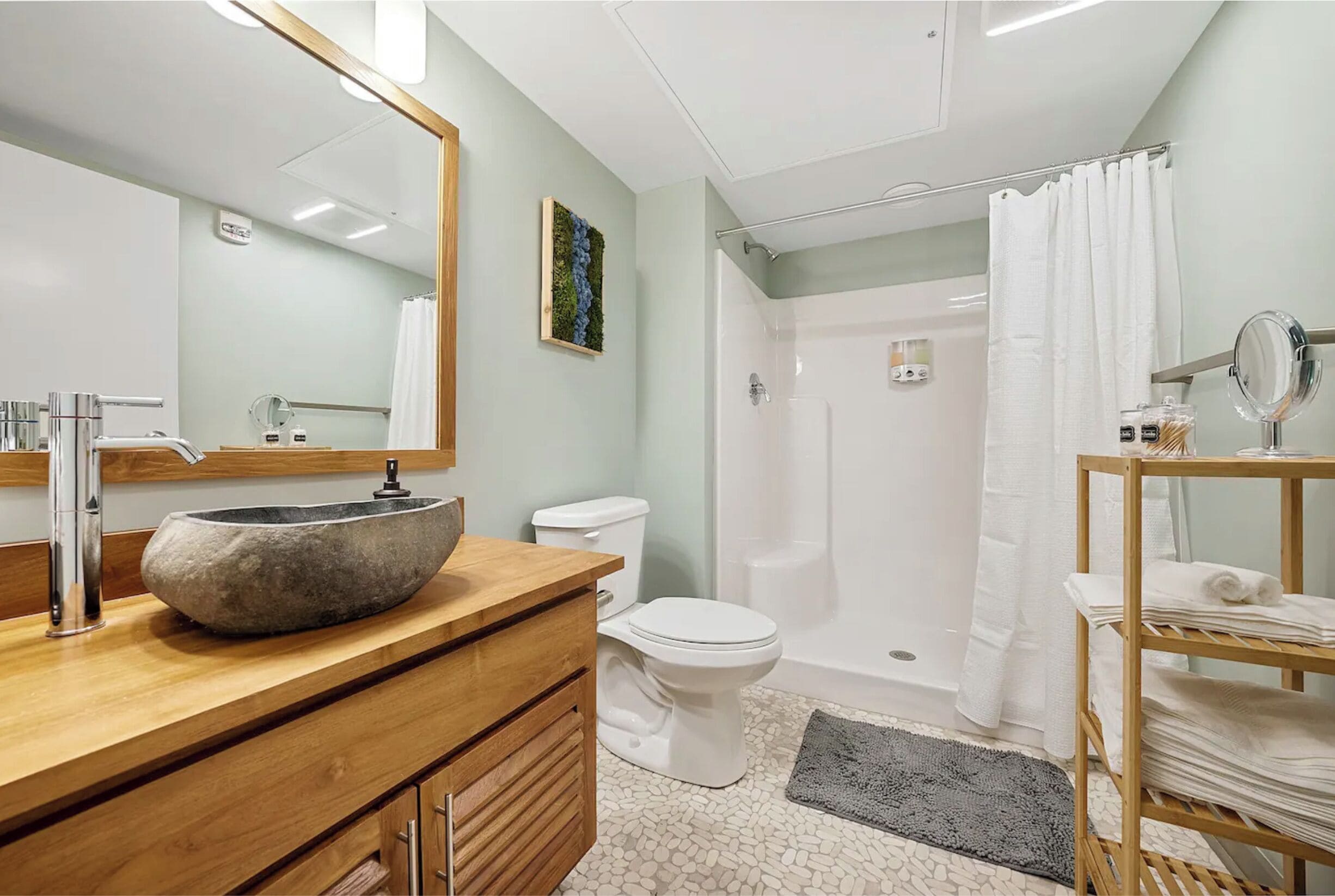 Ein modernes Badezimmer mit einem Steintonne, einer weißen Toilette und einer Duschkabine.