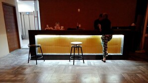 A reception area with a counter, two stools, and a tiled floor.