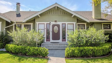 A two-story house with a front porch, a mailbox, and a number plaque.