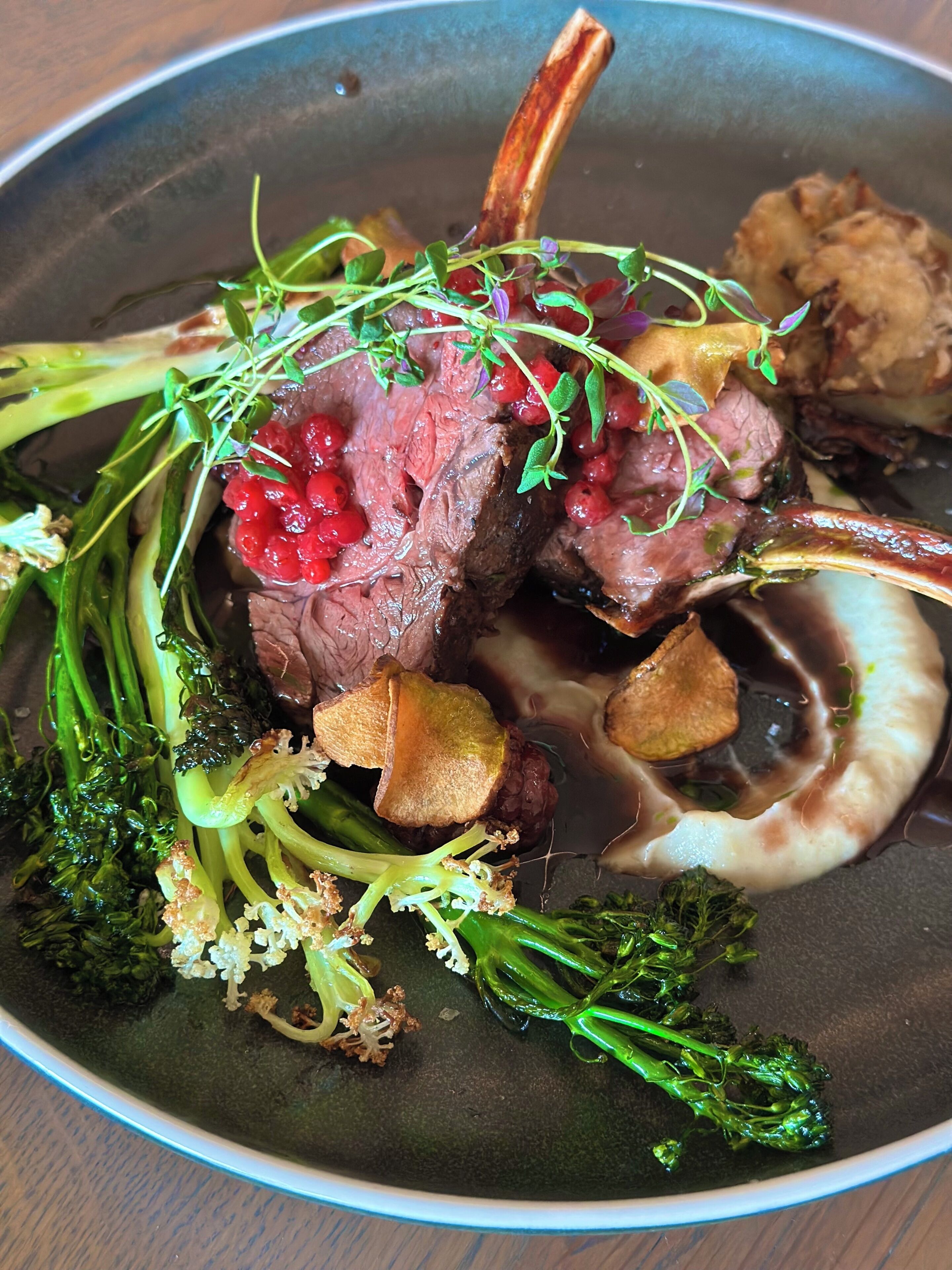 A plate of food with meat, vegetables, and berries.