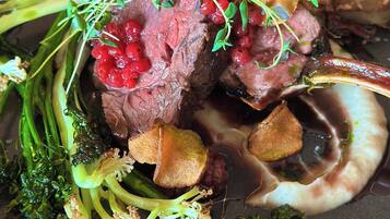 A plate of food with meat, vegetables, and berries.