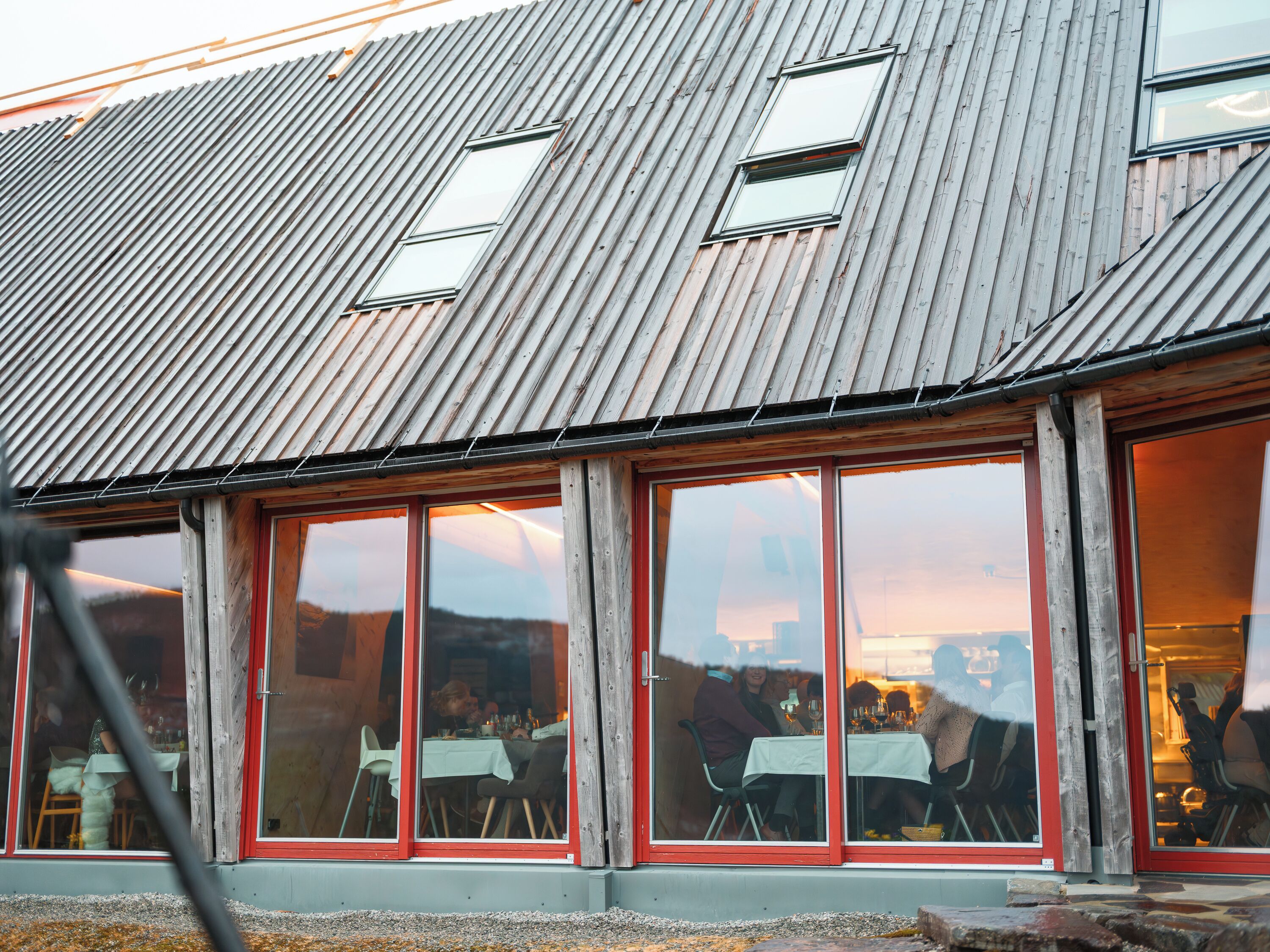 A building with large windows and a corrugated metal roof.