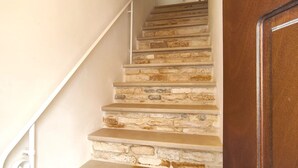 A staircase with stone steps and a white handrail.