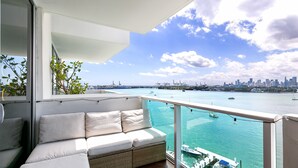 A balcony with a white sofa, a view of the water, and boats. - Best view in Miami Beach (Miami Beach)