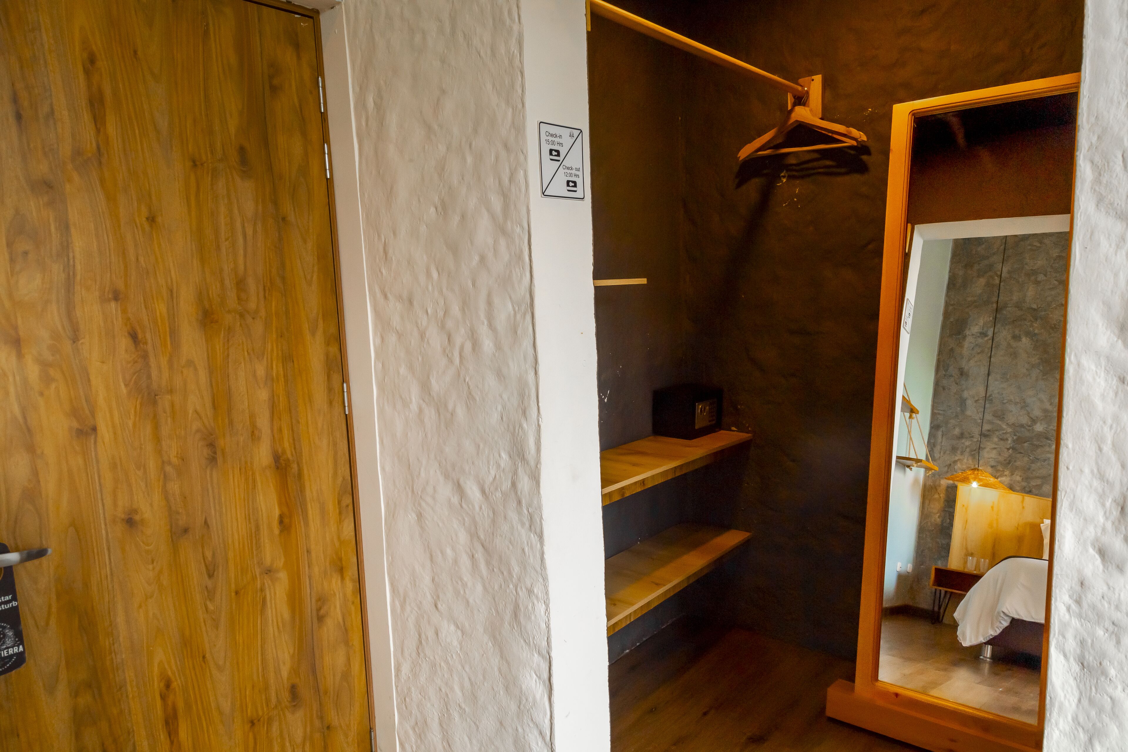 Een badkamer met een houten deur, een handdoekhouder en een spiegel.