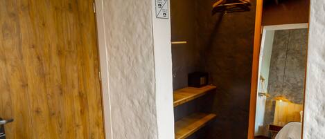 Een badkamer met een houten deur, een handdoekhouder en een spiegel.