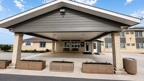 Un hôtel Days Inn doté d’une entrée abritée, d’un espace extérieur aménagé avec des sièges et de jardinières.