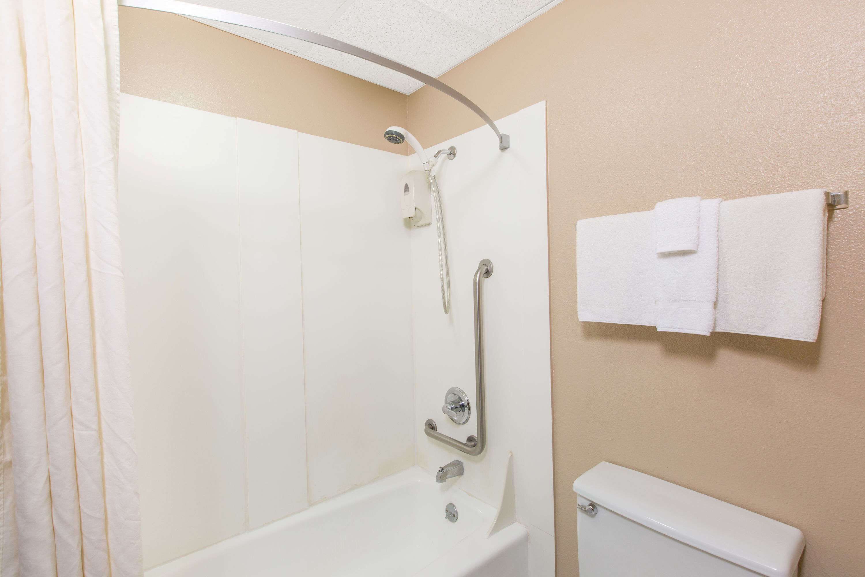 Une salle de bain équipée d’une douche, de toilettes et d’un porte-serviettes.
