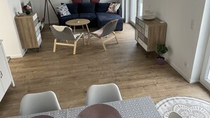 Una sala de estar moderna con un sofá, dos sillones, una mesita y un mueble.