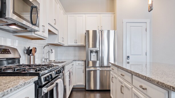 A modern kitchen with white cabinets, stainless steel appliances, and granite countertops. - Chic 3-Bed Condo, 2-Car Garage close to Pearl & St. Mary's Strip in Tobin Hills! (San Antonio)