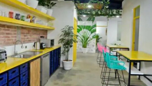 Una cocina moderna con encimera amarilla, almacenamiento azul y salpicadero de ladrillo.
