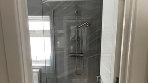 A modern shower area with a glass door, a handheld showerhead, and a wall-mounted faucet. - 1bedhouse- London-sleeps 4- Close to Attractions (London)