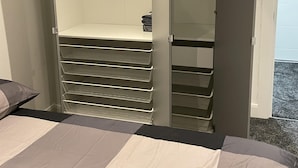 A bedroom with a bed, a closet with hanging space, and a storage unit. - 1bedhouse- London-sleeps 4- Close to Attractions (London)