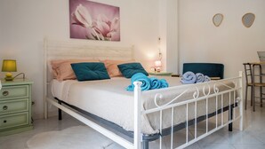 A neatly made bed with pillows, a bedside lamp, and a wall-mounted picture.