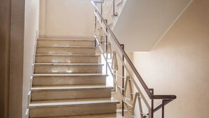 A staircase with a handrail and a window at the top.