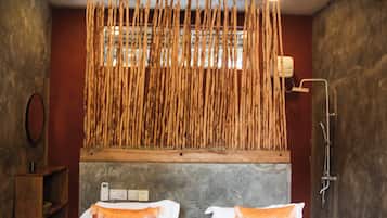 A hotel room with a bed, a ceiling fan, and a wall-mounted wooden rack.