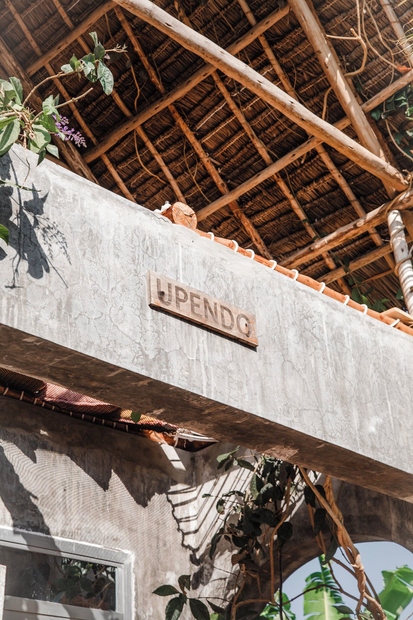 A building with a sign reading 'UPENDG' and a thatched roof.