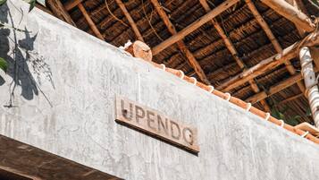 A building with a sign reading 'UPENDG' and a thatched roof.