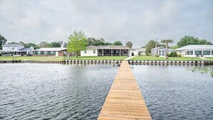 A waterfront property with a wooden dock leading to a house. - Tranquil Lakefront Retreat (Lake Placid)