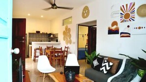 A modern living room with a sofa, chairs, a coffee table, and a dining area with a table and chairs.