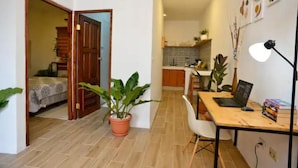 A compact living space with a bedroom, a dining area, and a kitchenette.