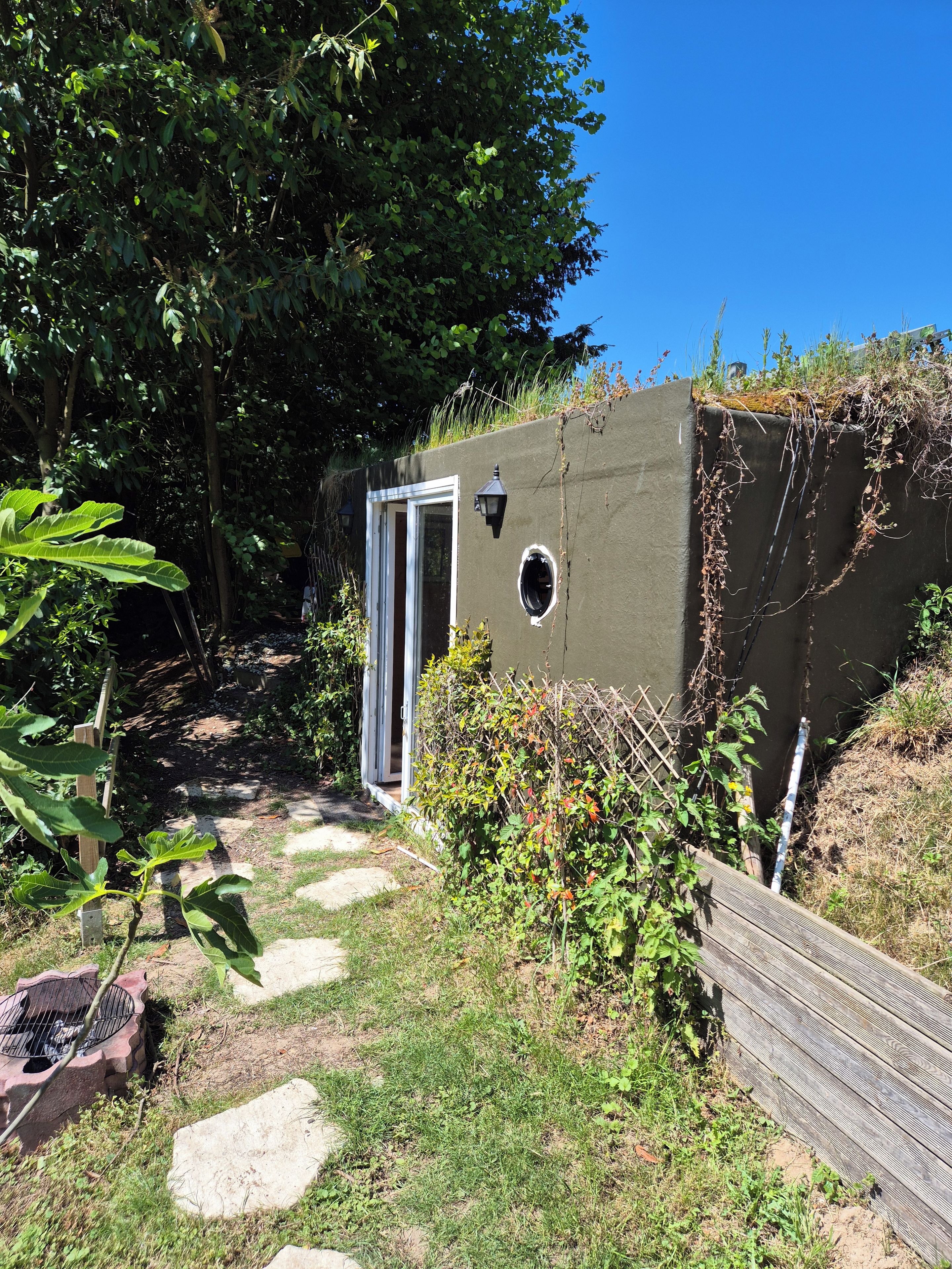Un petit espace extérieur clos, avec une porte donnant sur un jardin.