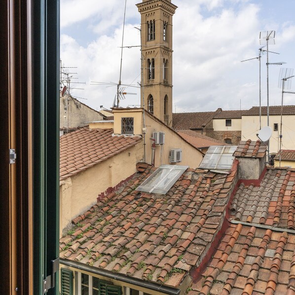 A view of terracotta-tiled rooftops with a prominent tower structure in the background. - Porcellana 4 in Florence (Florence)