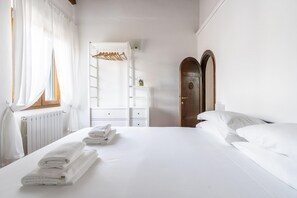 Relax in a spacious room with a large bed, a wardrobe, and a mirror.