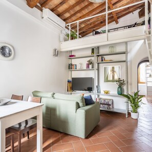 Relax in this inviting living area with a comfortable sofa, dining table, and bookshelf.
