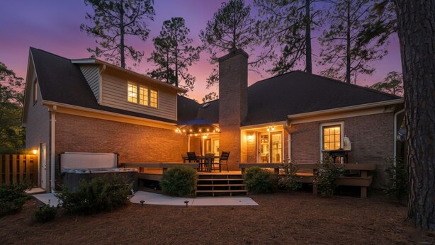 A two-story house with a covered patio, a fireplace, and a chimney. - +Golf cart +Jacuzzi + Ping Pong + 0.6 miles to Historic Village and Pinehurst #2 (Pinehurst)