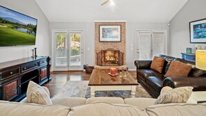A living room with a fireplace, a large flat-screen TV, a leather sofa, and a wooden coffee table. - +Golf cart +Jacuzzi + Ping Pong + 0.6 miles to Historic Village and Pinehurst #2 (Pinehurst)