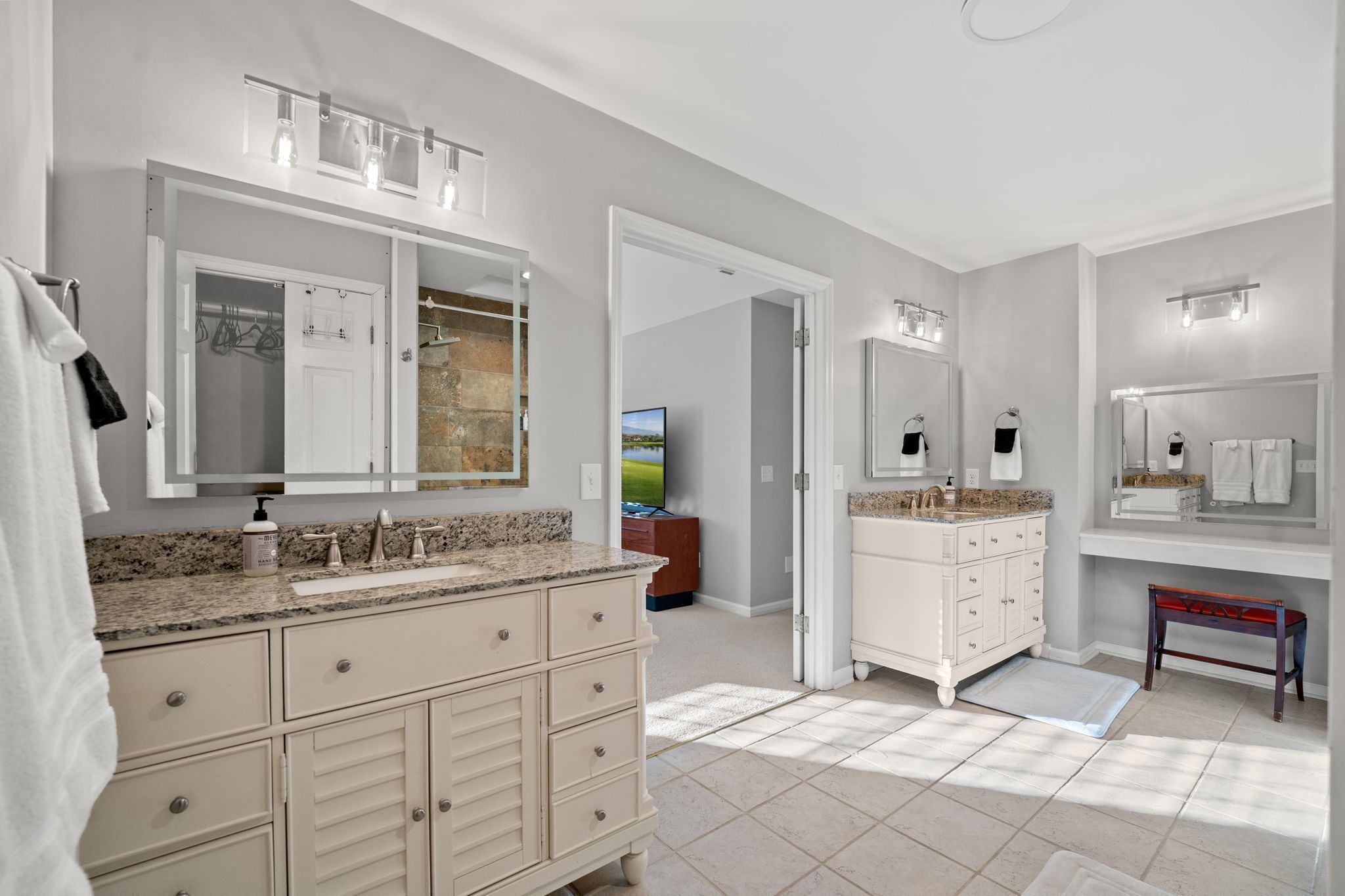 Un baño moderno con dos lavamanos, un espejo grande y un mueble de tocador con cajones.