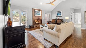 A living room with a fireplace, a sofa, a TV, and a ceiling fan. - +Golf cart +Jacuzzi + Ping Pong + 0.6 miles to Historic Village and Pinehurst #2 (Pinehurst)