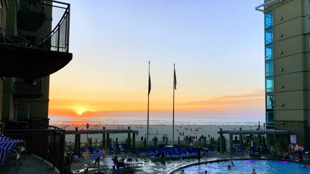 A pool area with a sunset view, lounge chairs, and a beach in the background. - Worldmark Seaside, Beachfront Resort!! Add Nights 5, 6 &7 only 50 each. (Seaside)