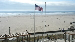 A beach with an American flag, a playground, and a boardwalk with seating. - Worldmark Seaside, Beachfront Resort!! Add Nights 5, 6 &7 only 50 each. (Seaside)