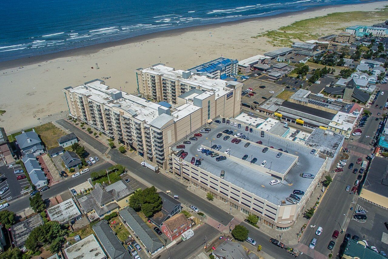 Un hôtel à plusieurs étages doté d’un parking et offrant une vue sur la plage.