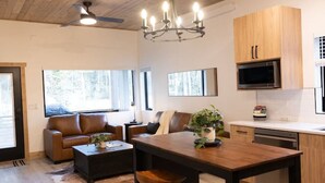 Una cocina moderna con armarios de madera, una mesa de comedor con taburetes y una lámpara de araña.