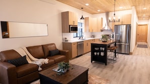 Una cocina moderna con armarios de madera, electrodomésticos de acero inoxidable y una isla central.