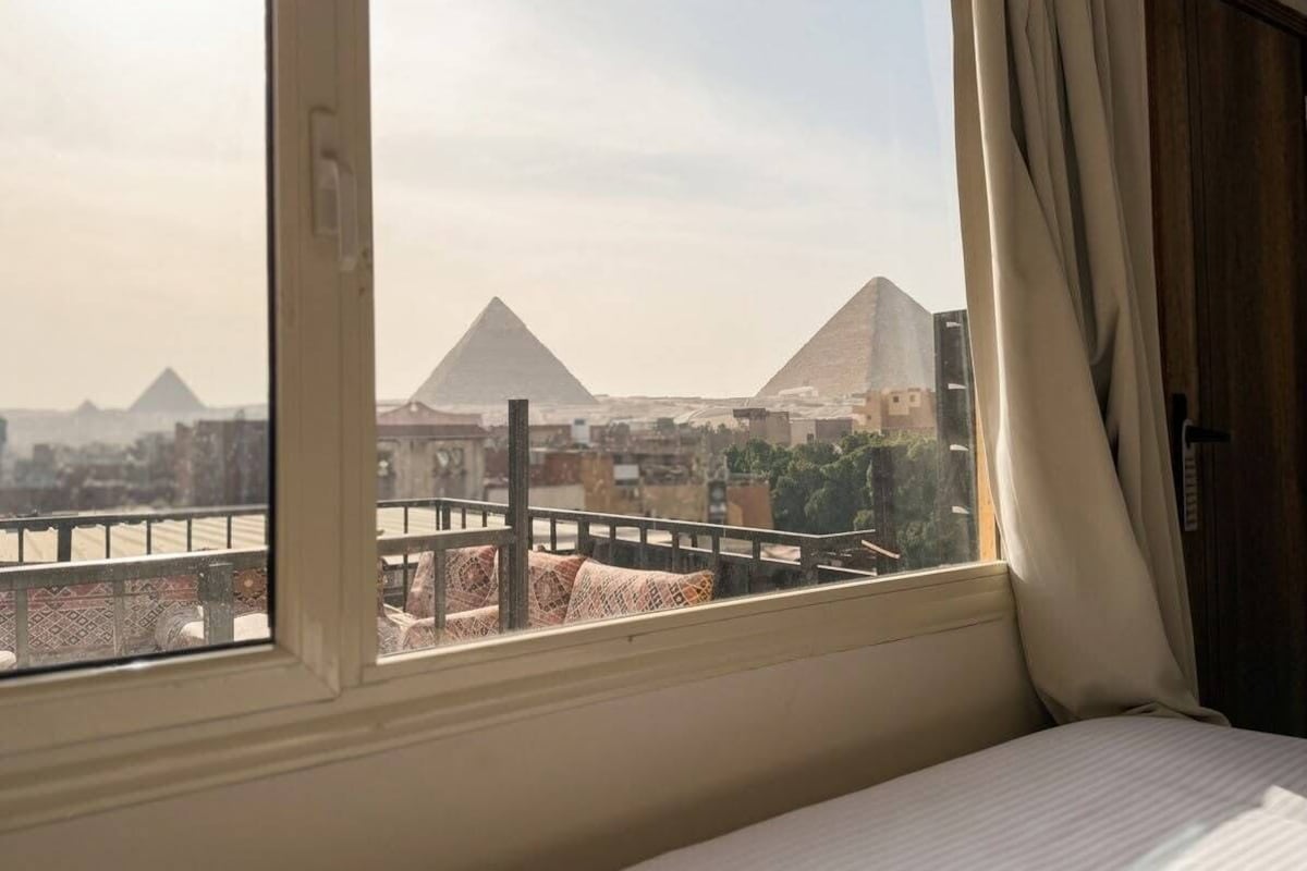 A room with a view of pyramids through a window.