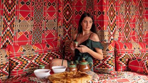 Una habitació amb parets amb disseny, un sofà, una taula amb un bol i una tetera.