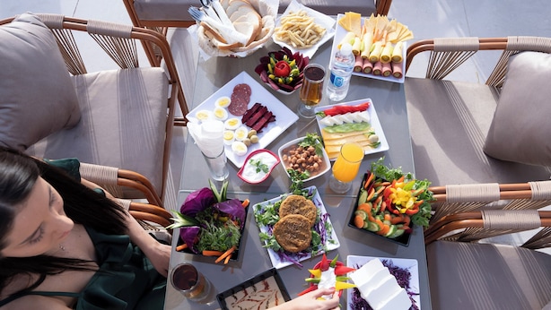 Taula de dinar preparada amb diversos aliments i una persona asseguda a la taula.