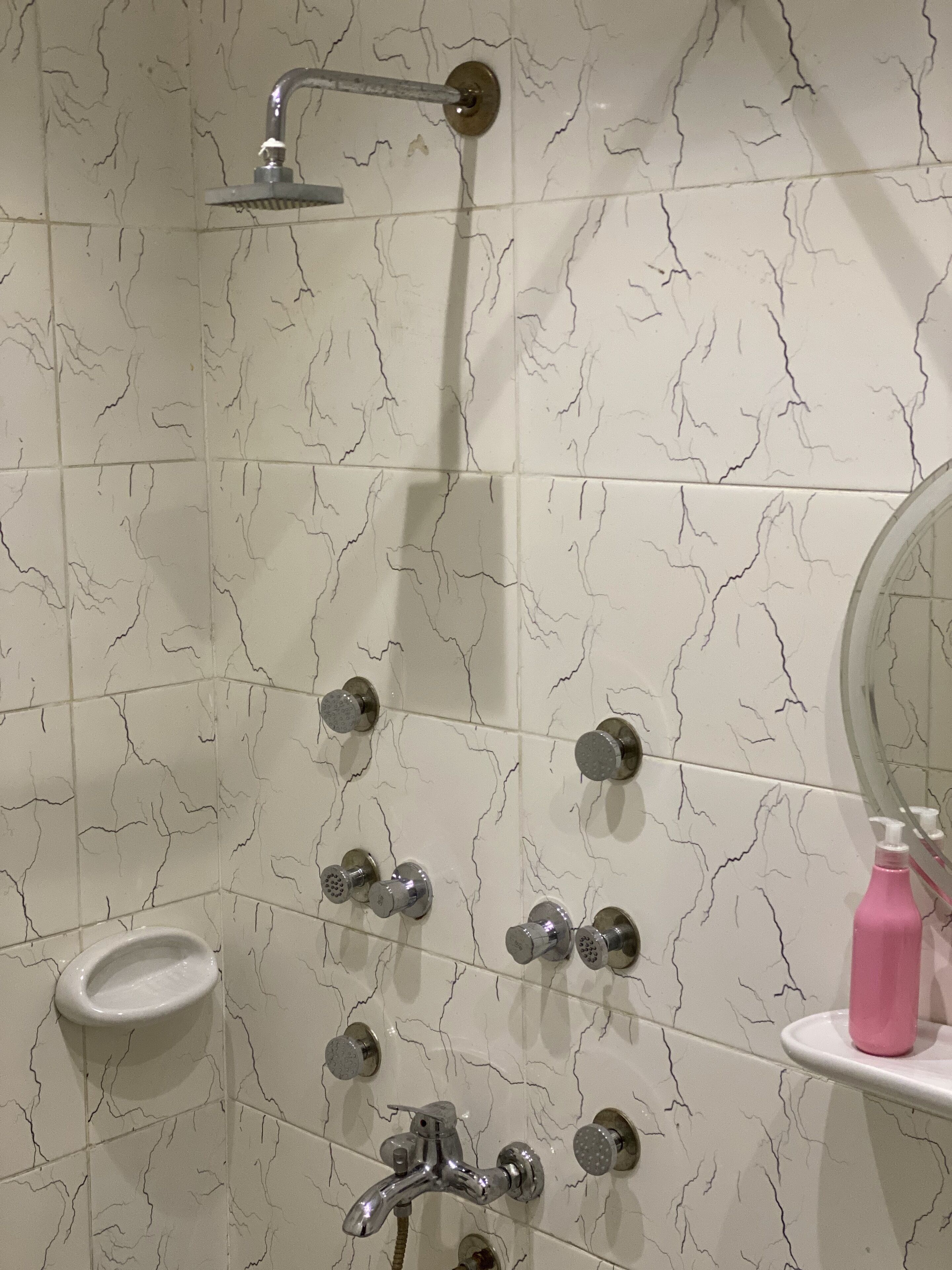 A bathroom with a shower, multiple faucets, a sink, and a mirror.