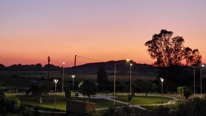 A sunset view over a park with pathways, trees, and street lamps. - Holiday Home Piscinas (SU)
Nice apartment a few kilometers from the sea (Piscinas)