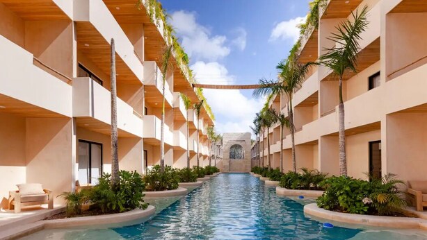 A pool area with a central water feature, surrounded by balconies with plants. - Magic jungle apartment in Tulum (Tulum)