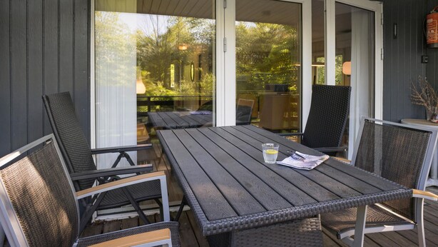 A covered patio with a table and chairs, large sliding glass doors, and a view of a garden. - Beautiful home in Toftlund with WiFi (Toftlund)