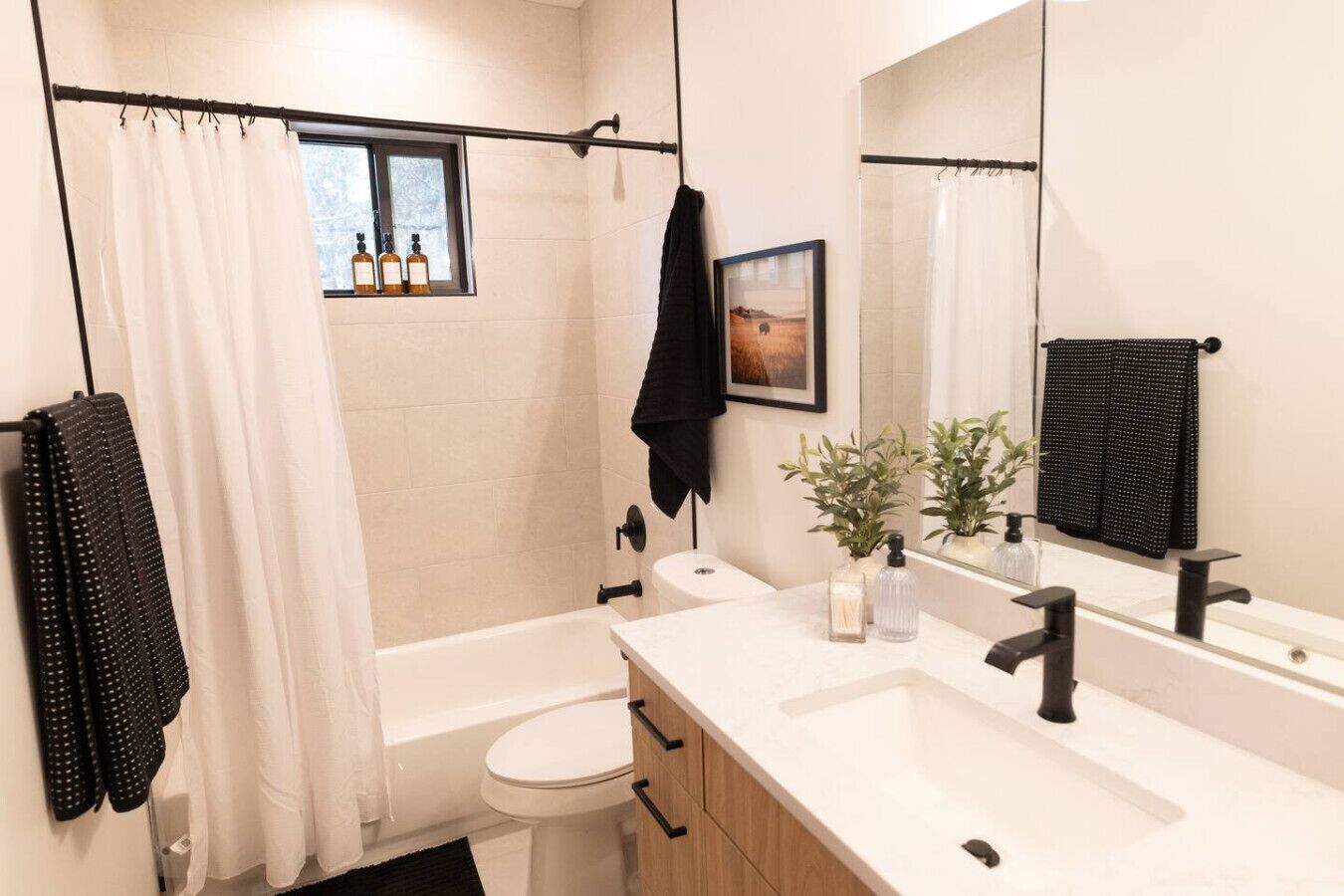 A modern bathroom with a bathtub, toilet, and vanity.