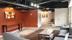 A modern interior with a sofa, a coffee table, and a bench. There are artworks on the walls and a door in the background. - THE INN- PITTSBURGH (Pittsburgh)