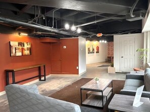 A modern interior with a sofa, a coffee table, and a bench. There are artworks on the walls and a door in the background. - THE INN- PITTSBURGH (Pittsburgh)